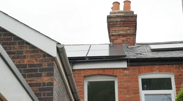 The roof of the retrofitted terrace with solar panels on the slates and a new window below