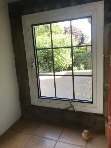 An uninsulated reconstituted-stone window surround bridging through the wall