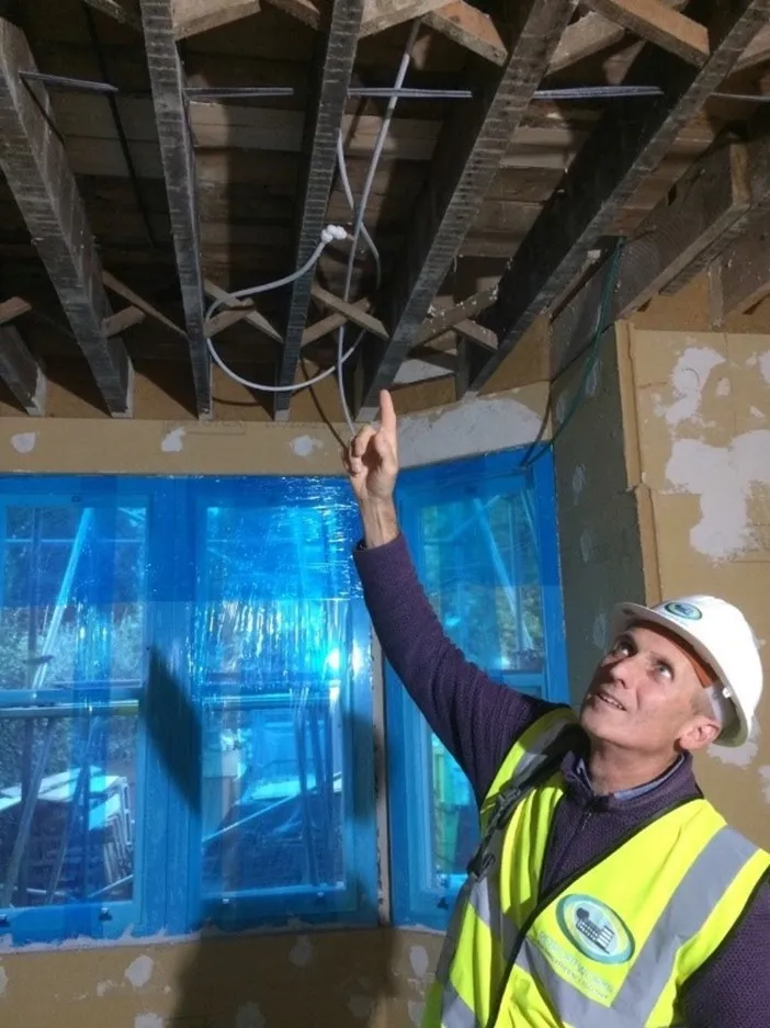 A ceiling opened to the joists during the works, with the new sash windows protected in film